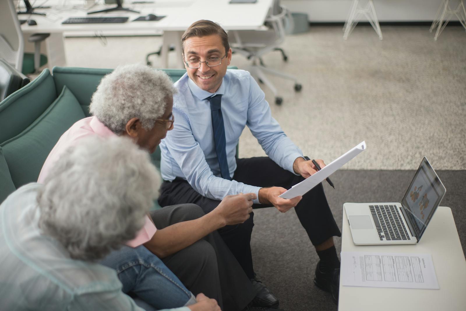 Man presenting information to two elderly women
