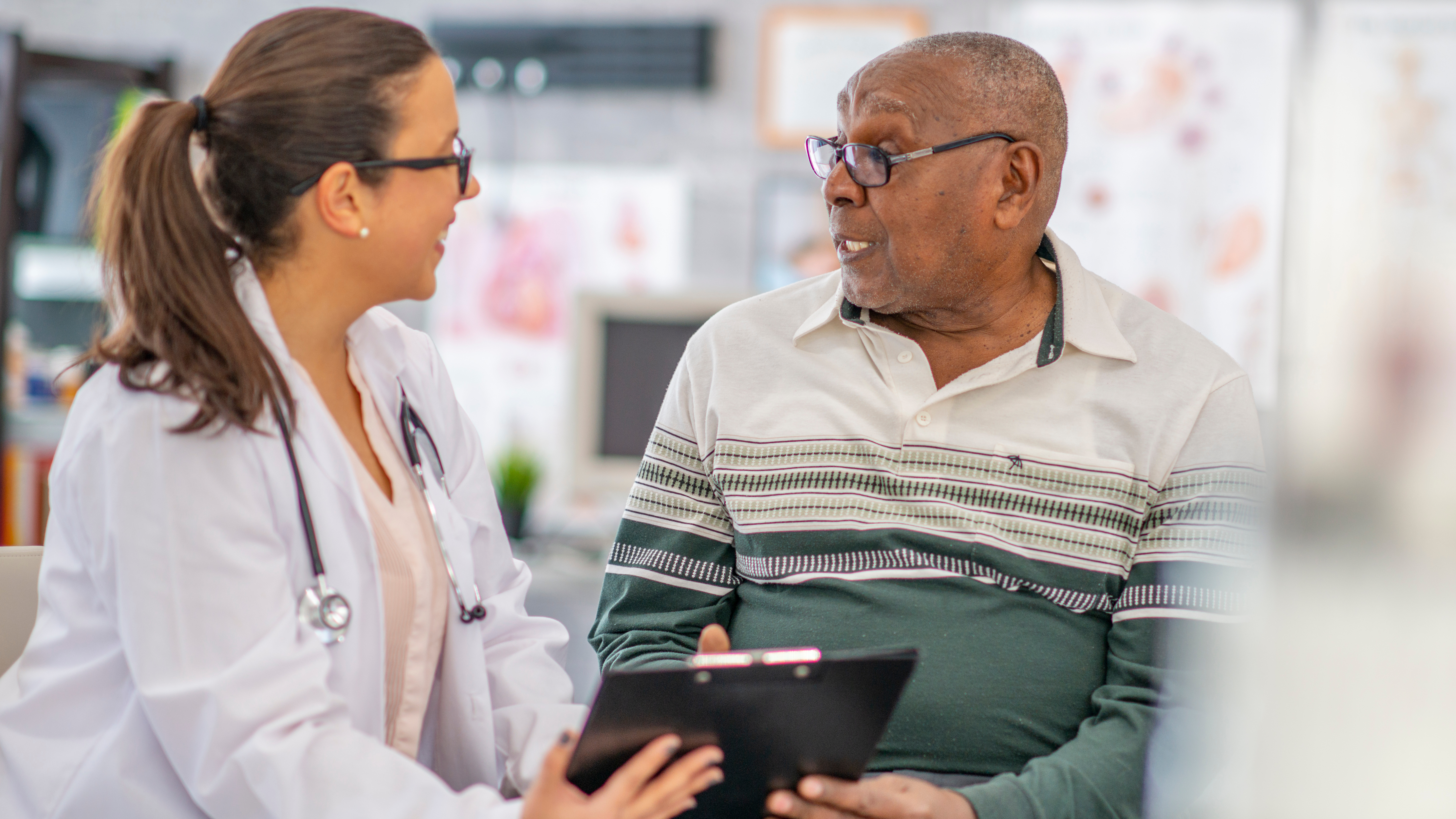 Doctor talking with an older patient during a medical checkup.
